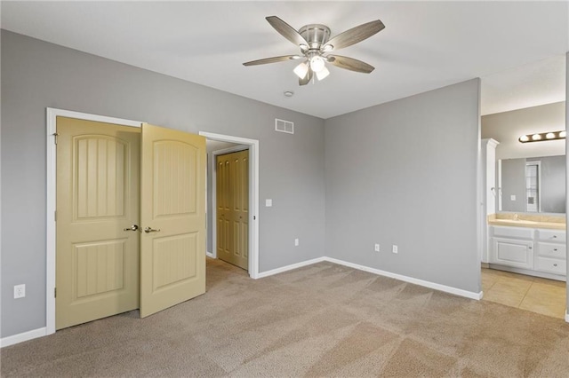 5245 Overland Dr, Lawrence, KS 66049 - unfurnished bedroom with light colored carpet, baseboards, connected bathroom, ceiling fan, and a sink