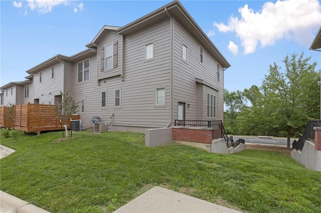 5245 Overland Dr, Lawrence, KS 66049 - back of house with a yard, cooling unit, and a wooden deck