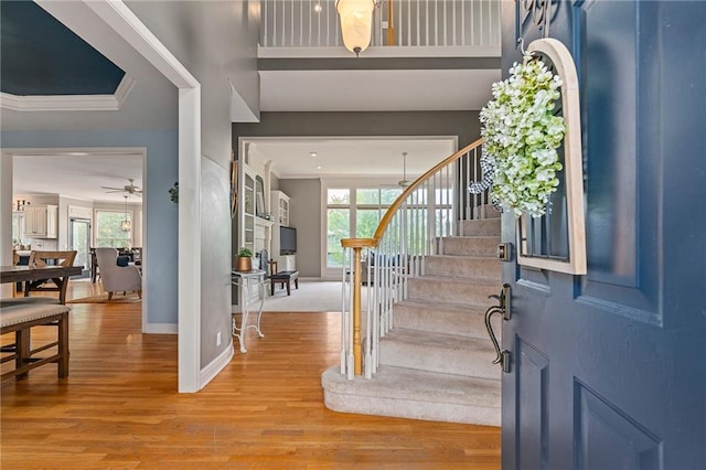 15998 Overbrook Ln, Overland Park, KS 66224 - foyer featuring plenty of natural light, stairway, wood finished floors, ceiling fan, and ornamental molding