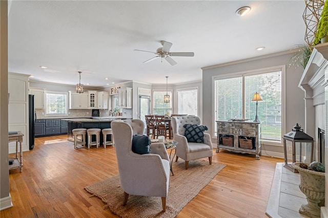 15998 Overbrook Ln, Overland Park, KS 66224 - living room with a fireplace, ornamental molding, a ceiling fan, light wood finished floors, and recessed lighting