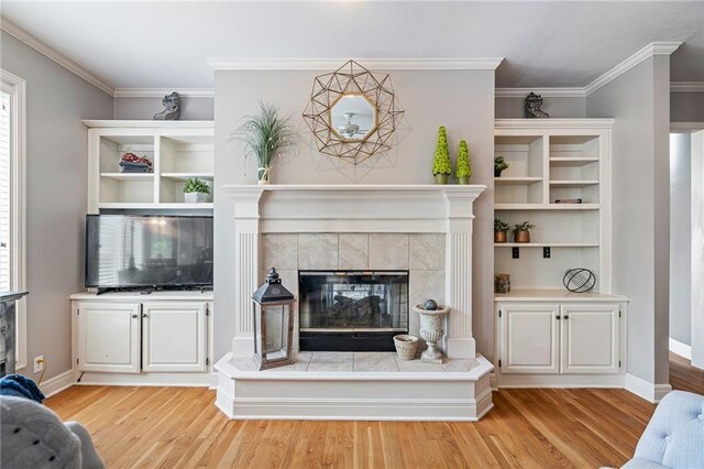 15998 Overbrook Ln, Overland Park, KS 66224 - living room featuring a tile fireplace, light wood-style floors, and ornamental molding
