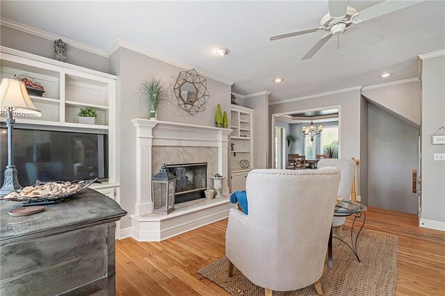 15998 Overbrook Ln, Overland Park, KS 66224 - living room with light wood-type flooring, a ceiling fan, crown molding, recessed lighting, and a premium fireplace