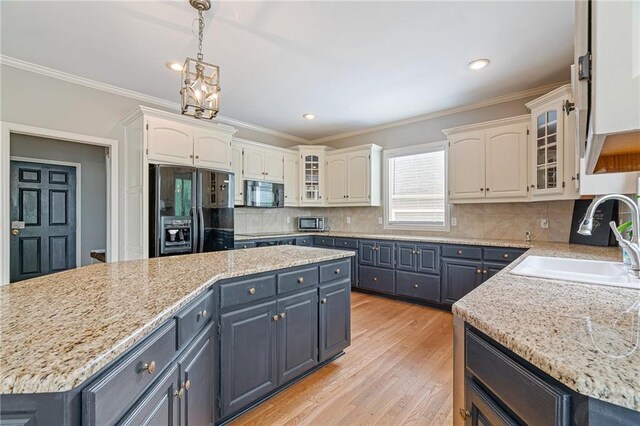 15998 Overbrook Ln, Overland Park, KS 66224 - kitchen with black appliances, white cabinetry, glass insert cabinets, decorative light fixtures, and light wood-style flooring