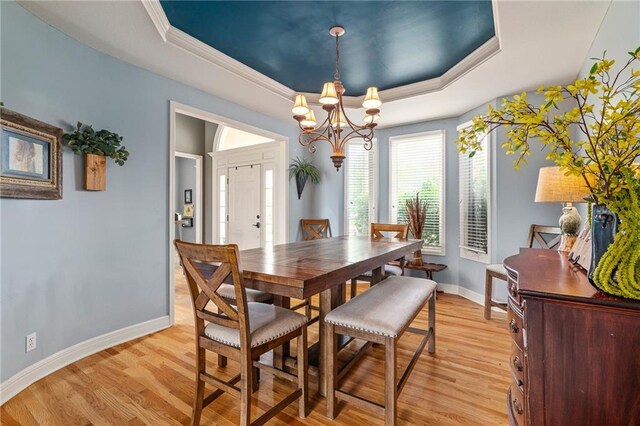 15998 Overbrook Ln, Overland Park, KS 66224 - dining room with a tray ceiling, a chandelier, light wood-type flooring, and crown molding