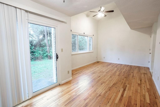 255 N Michigan St Unit 1-2, Lawrence, KS 66044 - unfurnished living room with light wood finished floors, a textured ceiling, ceiling fan, baseboards, and lofted ceiling