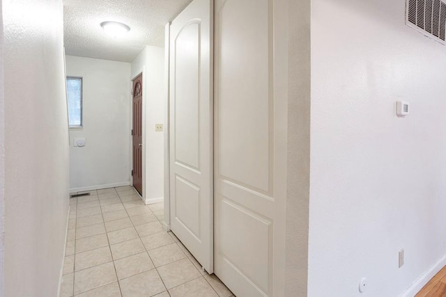 255 N Michigan St Unit 1-2, Lawrence, KS 66044 - hall featuring a textured ceiling, light tile patterned flooring, and baseboards