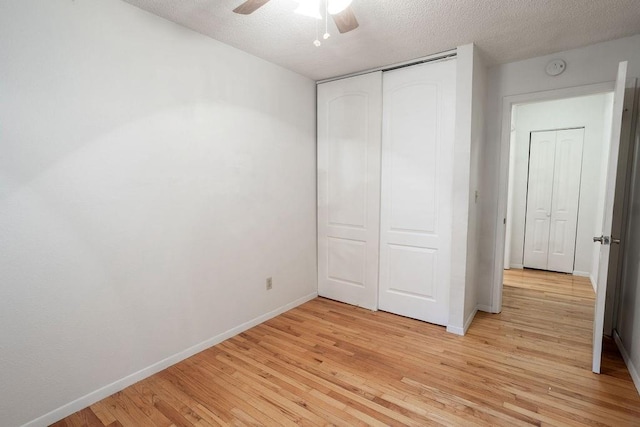 255 N Michigan St Unit 1-2, Lawrence, KS 66044 - unfurnished bedroom with light wood-style flooring, baseboards, a textured ceiling, a closet, and ceiling fan