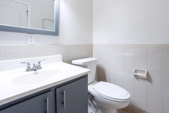 255 N Michigan St Unit 1-2, Lawrence, KS 66044 - bathroom with tile walls, toilet, vanity, and a wainscoted wall