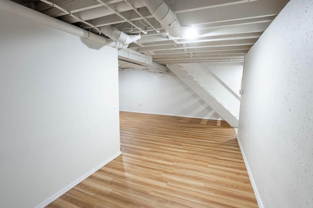 255 N Michigan St Unit 1-2, Lawrence, KS 66044 - finished basement with baseboards, wood finished floors, and stairway