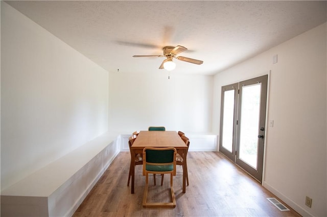 1739 W 26th St, Lawrence, KS 66047 - dining area featuring healthy amount of natural light, wood finished floors, a ceiling fan, and a textured ceiling
