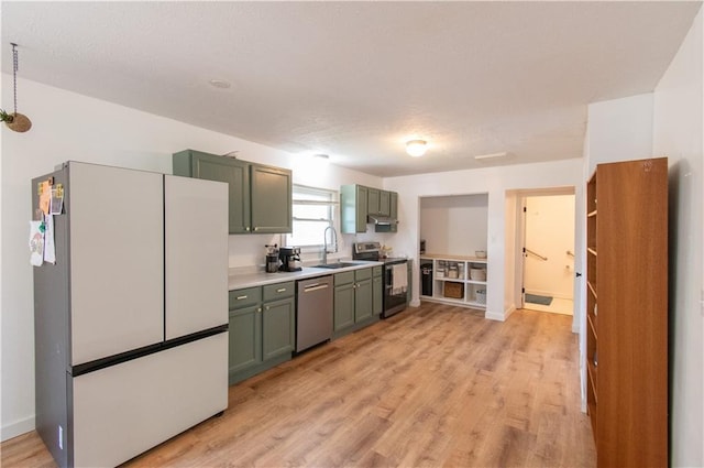 1739 W 26th St, Lawrence, KS 66047 - kitchen featuring appliances with stainless steel finishes, green cabinetry, and light wood-style flooring