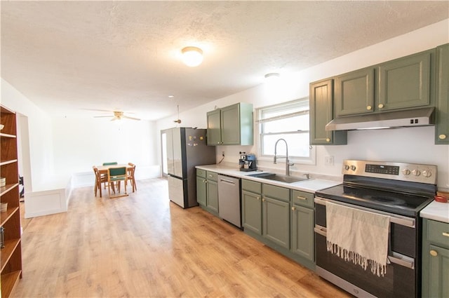 1739 W 26th St, Lawrence, KS 66047 - kitchen featuring stainless steel appliances, under cabinet range hood, green cabinets, light countertops, and a textured ceiling