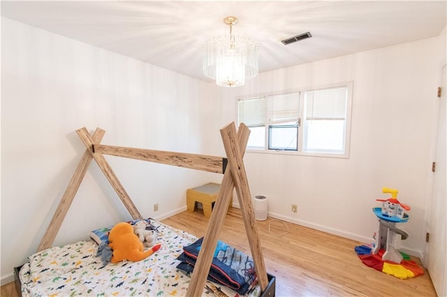 1739 W 26th St, Lawrence, KS 66047 - bedroom featuring a chandelier and wood finished floors