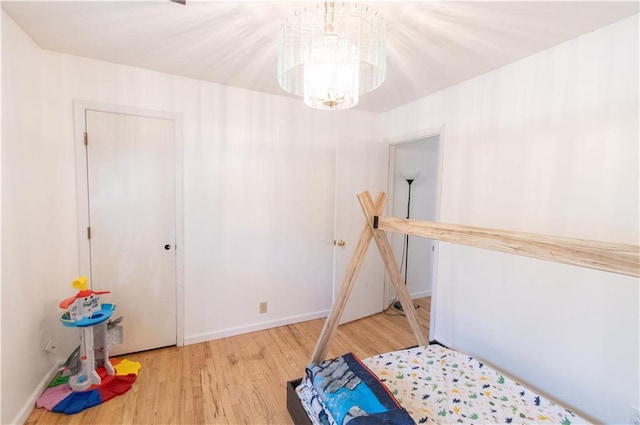 1739 W 26th St, Lawrence, KS 66047 - unfurnished bedroom with wood finished floors and a chandelier