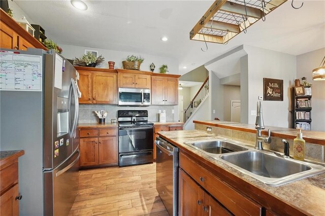 207 N Laurel St Unit 5D, Gardner, KS 66030 - kitchen with appliances with stainless steel finishes, light wood finished floors, decorative backsplash, recessed lighting, and brown cabinetry