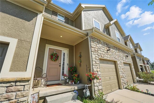 207 N Laurel St Unit 5D, Gardner, KS 66030 - entrance to property featuring stucco siding, stone siding, an attached garage, and driveway
