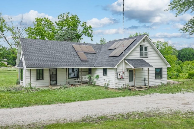 4207 10th Ave, Leavenworth, KS 66048 - view of front of house with a shingled roof, a porch, roof mounted solar panels, and a front lawn