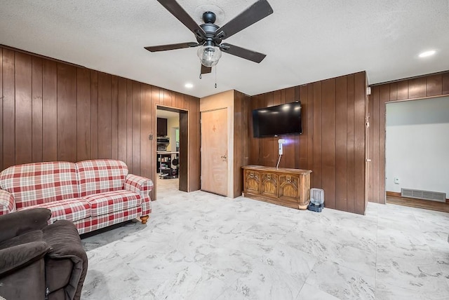 4207 10th Ave, Leavenworth, KS 66048 - living room featuring a ceiling fan, wooden walls, recessed lighting, and a textured ceiling