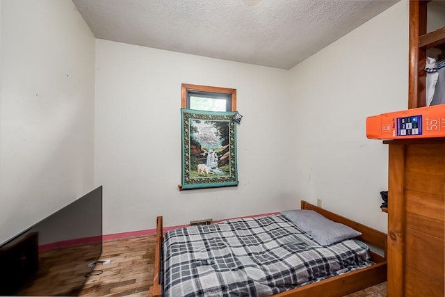 4207 10th Ave, Leavenworth, KS 66048 - bedroom with wood finished floors and a textured ceiling