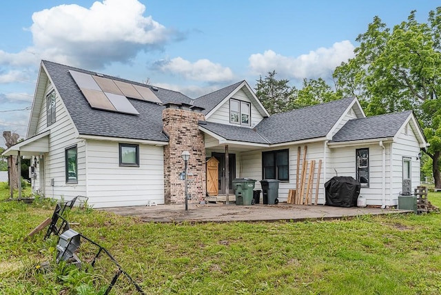 4207 10th Ave, Leavenworth, KS 66048 - rear view of house with a shingled roof, a patio, solar panels, and a yard