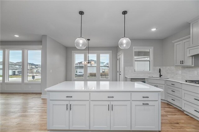 6018 Arapahoe St, Shawnee, KS 66226 - kitchen with a sink, light countertops, tasteful backsplash, light wood-type flooring, and recessed lighting