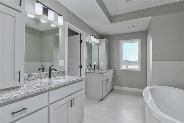 6018 Arapahoe St, Shawnee, KS 66226 - full bathroom with two vanities, a freestanding bath, and baseboards
