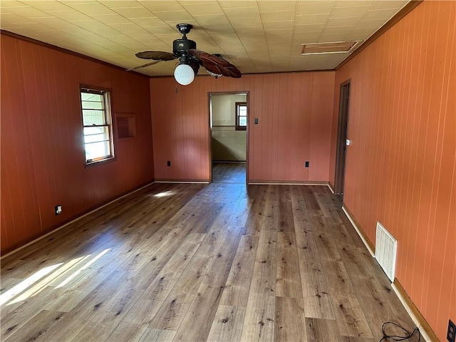117 E 23rd St, Pittsburg, KS 66762 - unfurnished room featuring hardwood / wood-style flooring, healthy amount of natural light, a ceiling fan, wooden walls, and crown molding