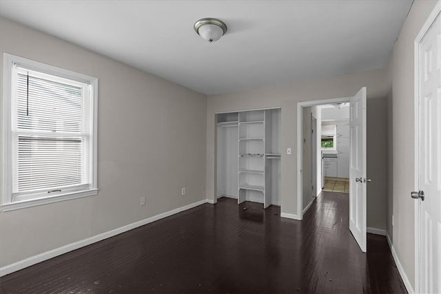 506 Hereford Ave, Independence, MO 64055 - unfurnished bedroom featuring dark wood-style flooring, baseboards, and a closet