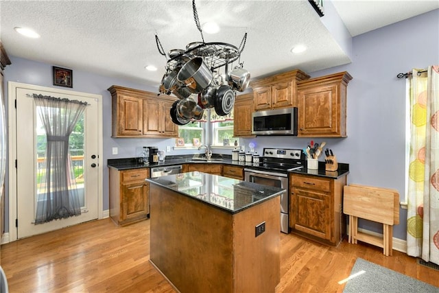 4316 Grand Ave, Leavenworth, KS 66048 - kitchen with stainless steel appliances, brown cabinetry, a sink, a textured ceiling, and recessed lighting