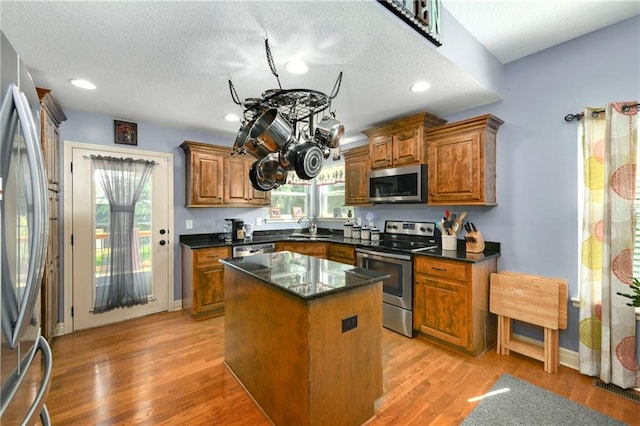 4316 Grand Ave, Leavenworth, KS 66048 - kitchen with stainless steel appliances, a sink, brown cabinetry, plenty of natural light, and a textured ceiling