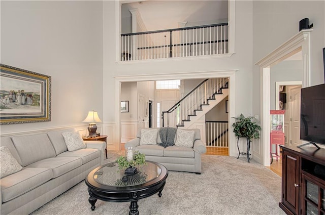 18765 S Alden St, Olathe, KS 66062 - carpeted living room featuring a towering ceiling, stairway, and a wainscoted wall