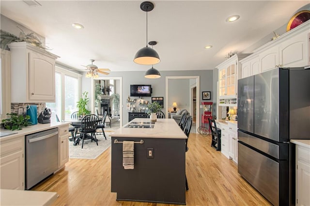 18765 S Alden St, Olathe, KS 66062 - kitchen featuring stainless steel appliances, light countertops, white cabinetry, light wood finished floors, and recessed lighting