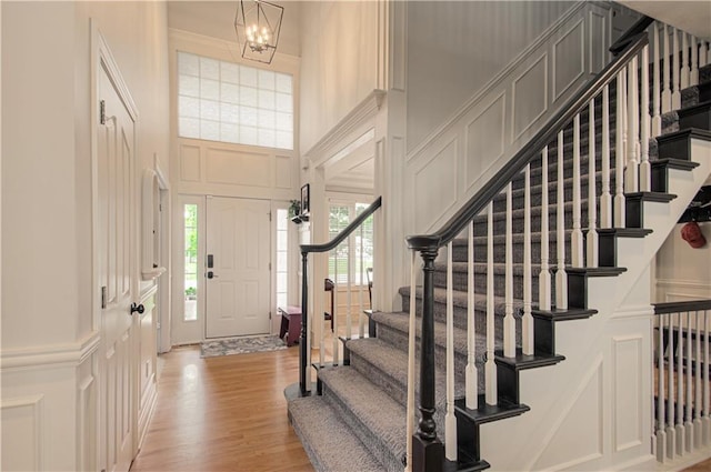 18765 S Alden St, Olathe, KS 66062 - entrance foyer with a decorative wall, stairway, a towering ceiling, light wood-style floors, and a chandelier