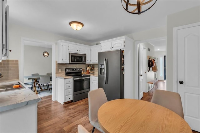 1610 Renea Ct, Kearney, MO 64060 - kitchen featuring stainless steel appliances, a sink, backsplash, and white cabinetry