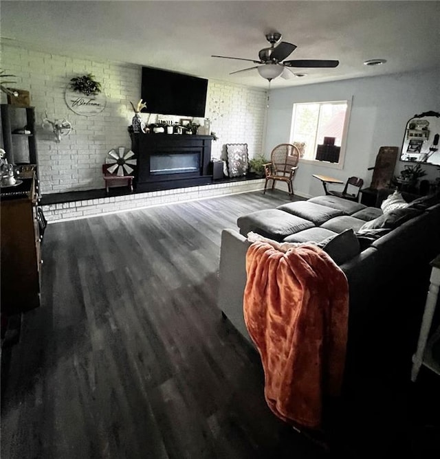 414 S 3rd St, Humboldt, KS 66748 - living room with a glass covered fireplace, wood finished floors, brick wall, and a ceiling fan