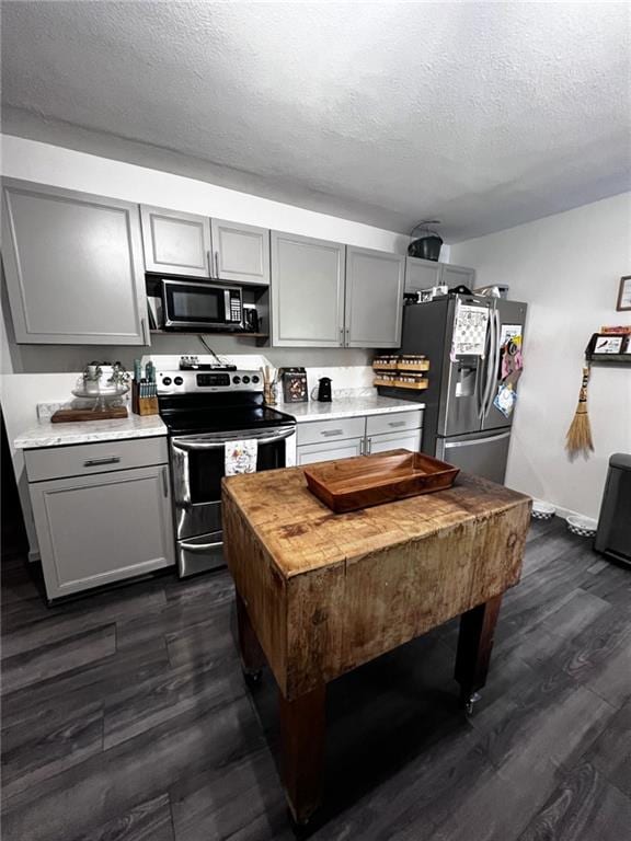 414 S 3rd St, Humboldt, KS 66748 - kitchen featuring stainless steel appliances, gray cabinets, dark wood finished floors, and a textured ceiling