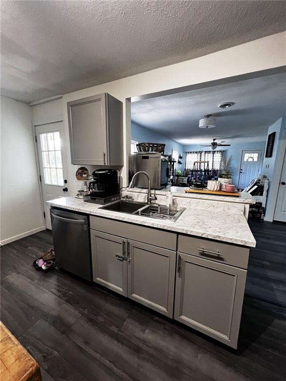 414 S 3rd St, Humboldt, KS 66748 - kitchen featuring gray cabinetry, stainless steel dishwasher, a peninsula, dark wood-type flooring, and a textured ceiling