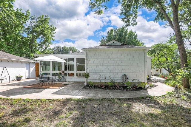 115 NE Green St, Lees Summit, MO 64063 - back of property with a patio area and a sunroom