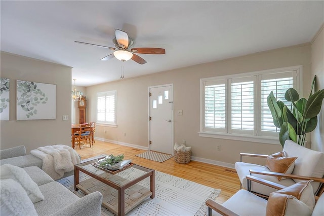 115 NE Green St, Lees Summit, MO 64063 - living room with light wood-style flooring, a ceiling fan, and a chandelier