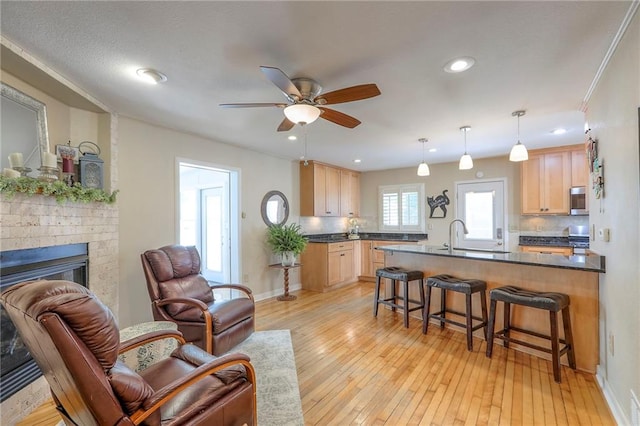 115 NE Green St, Lees Summit, MO 64063 - living area with ceiling fan, light wood-style floors, a fireplace, and recessed lighting