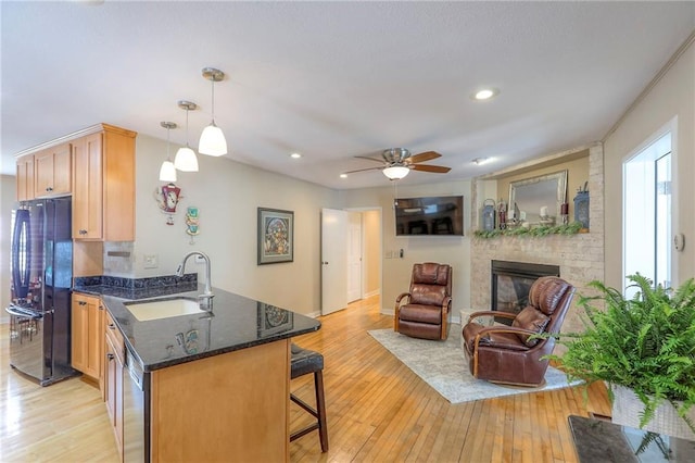 115 NE Green St, Lees Summit, MO 64063 - kitchen featuring freestanding refrigerator, a peninsula, light wood-type flooring, a kitchen breakfast bar, and recessed lighting