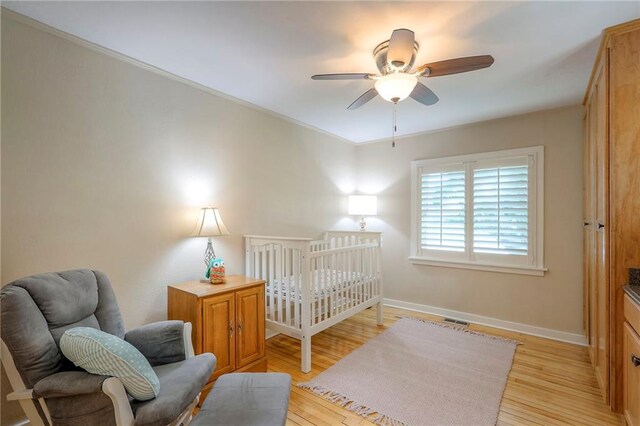 115 NE Green St, Lees Summit, MO 64063 - bedroom with light wood-style floors, ceiling fan, and ornamental molding
