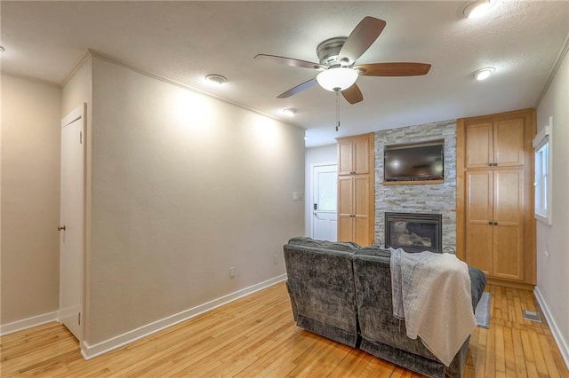 115 NE Green St, Lees Summit, MO 64063 - living room with light wood-style flooring, a ceiling fan, a fireplace, plenty of natural light, and crown molding