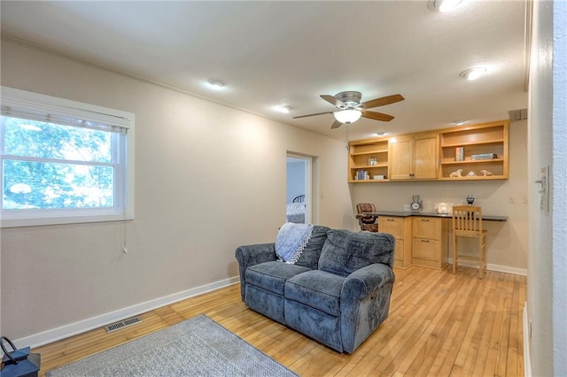 115 NE Green St, Lees Summit, MO 64063 - sitting room featuring built in desk, light wood finished floors, and a ceiling fan