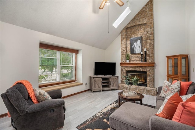 307 E Gore Rd, Raymore, MO 64083 - living area with a ceiling fan, a skylight, wood finished floors, a stone fireplace, and high vaulted ceiling