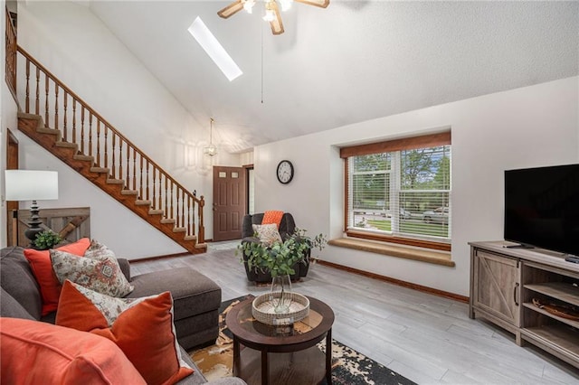 307 E Gore Rd, Raymore, MO 64083 - living room with ceiling fan, stairway, baseboards, wood finished floors, and a skylight
