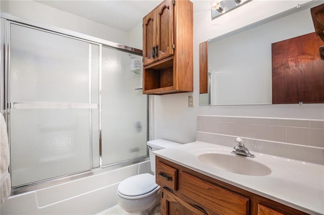307 E Gore Rd, Raymore, MO 64083 - bathroom featuring vanity, toilet, and shower / bath combination with glass door