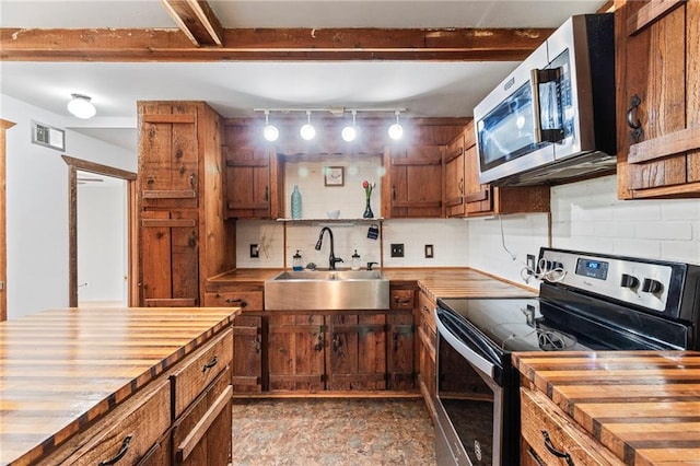 5470 SE Downing Rd, Lathrop, MO 64465 - kitchen featuring butcher block counters, appliances with stainless steel finishes, tasteful backsplash, and brown cabinets