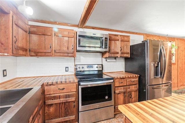 5470 SE Downing Rd, Lathrop, MO 64465 - kitchen featuring appliances with stainless steel finishes, wooden counters, tasteful backsplash, and brown cabinetry