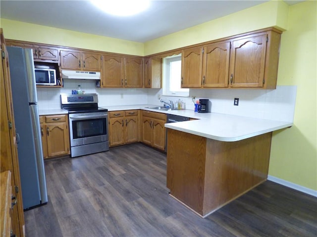 520 N Jefferson St, Raymore, MO 64030 - kitchen featuring stainless steel appliances, a peninsula, under cabinet range hood, a sink, and brown cabinets